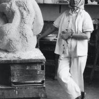 Charlotte van Pallandt aan het werk in haar atelier, op achtergrond het oude portret van koningin Juliana, 1958, foto